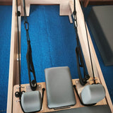 Pilates Reformer con topes de seguridad en los rieles